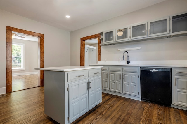 kitchen featuring dishwasher, dark wood-type flooring, sink, and a center island