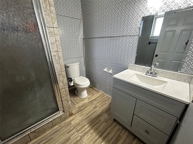 bathroom with walk in shower, vanity, and toilet