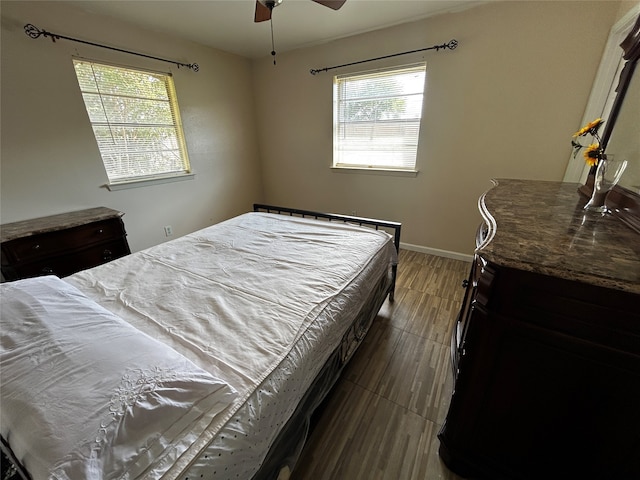 bedroom with ceiling fan and dark wood-type flooring