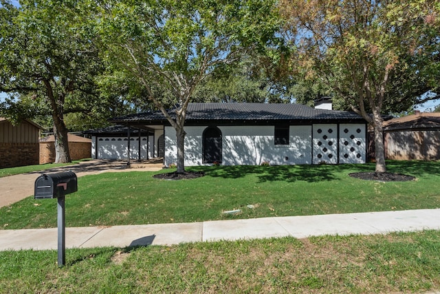 ranch-style house featuring a front yard and a garage