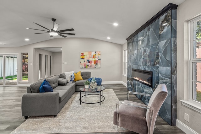 living room with a tile fireplace, lofted ceiling, hardwood / wood-style floors, and ceiling fan