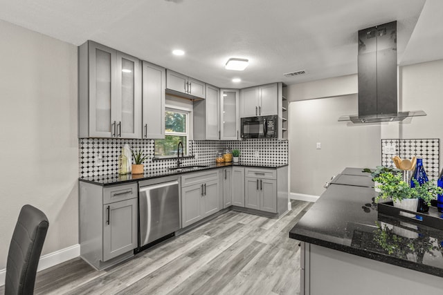 kitchen featuring gray cabinets, wall chimney range hood, and stainless steel dishwasher