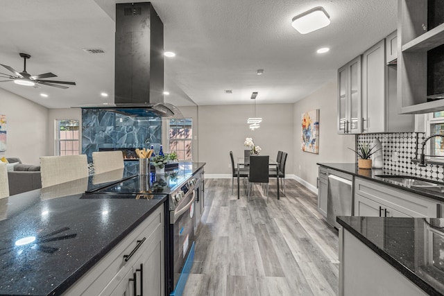 kitchen featuring backsplash, stainless steel appliances, exhaust hood, light hardwood / wood-style flooring, and sink