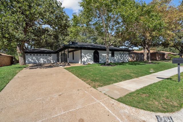 ranch-style house featuring a front yard and a garage