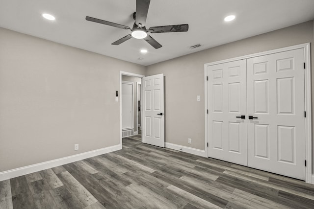 unfurnished bedroom featuring ceiling fan, a closet, and dark hardwood / wood-style floors