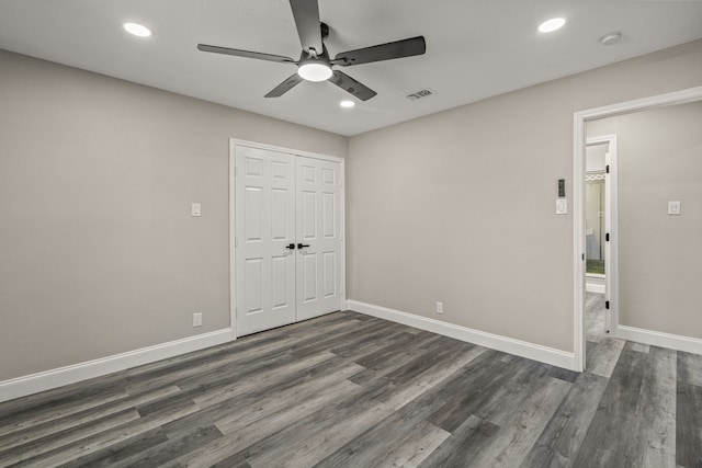 unfurnished bedroom with ceiling fan, a closet, and dark hardwood / wood-style floors