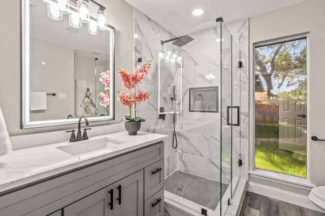 bathroom featuring walk in shower, vanity, toilet, and hardwood / wood-style flooring