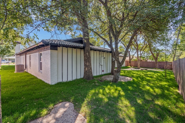 view of outbuilding featuring a yard and central AC