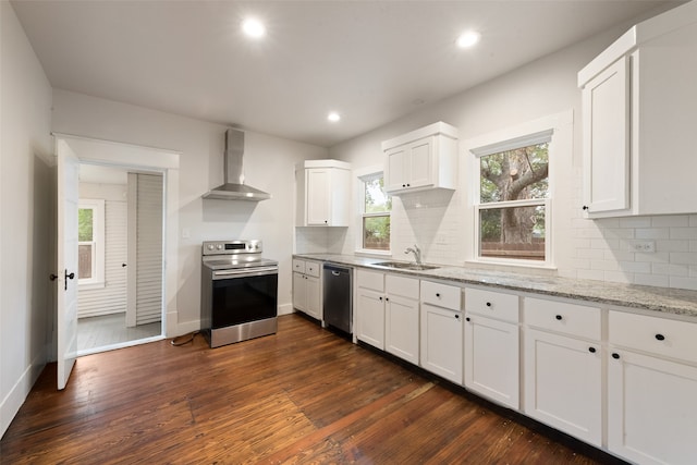 kitchen with light stone counters, appliances with stainless steel finishes, dark hardwood / wood-style floors, white cabinets, and wall chimney exhaust hood