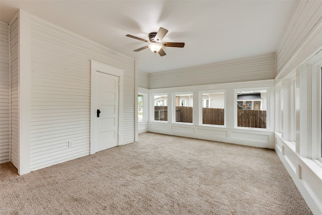 unfurnished sunroom with ceiling fan