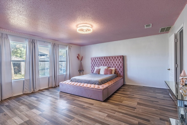 bedroom with wood-type flooring and a textured ceiling