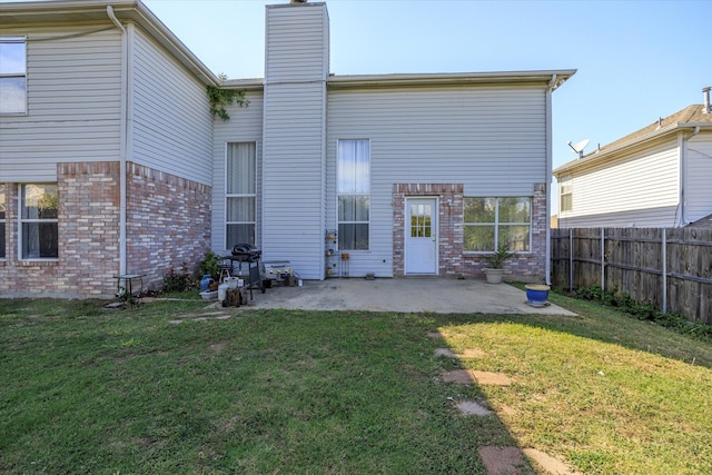 back of property featuring a yard and a patio