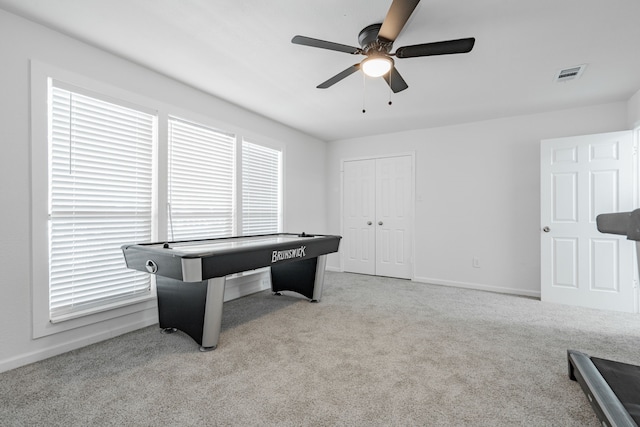 recreation room featuring light carpet and ceiling fan