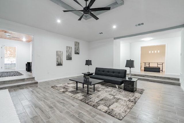 living room featuring a fireplace, ceiling fan, and light hardwood / wood-style flooring