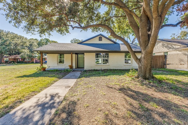 ranch-style house featuring a front yard and covered porch