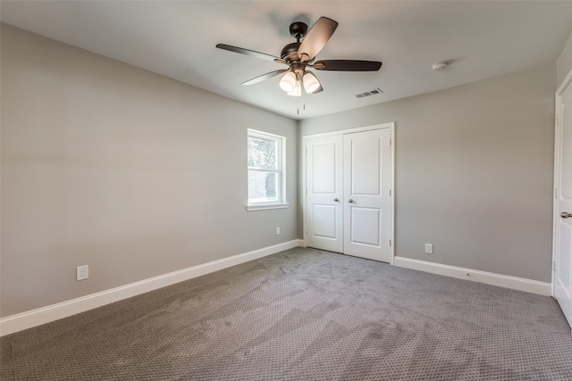 unfurnished bedroom with ceiling fan, carpet floors, and a closet