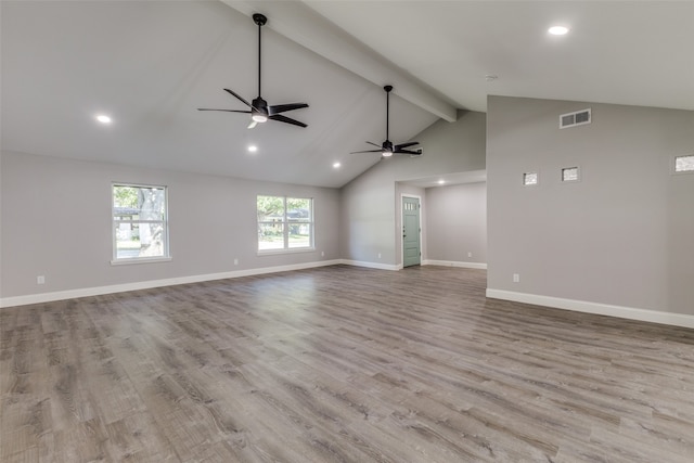 unfurnished living room with high vaulted ceiling, light wood-type flooring, beam ceiling, and ceiling fan