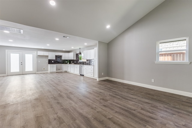 unfurnished living room featuring vaulted ceiling and hardwood / wood-style floors