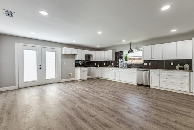 kitchen with dishwasher, tasteful backsplash, sink, white cabinets, and hardwood / wood-style floors