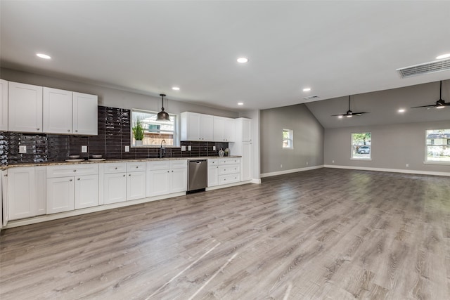 kitchen featuring stainless steel dishwasher, white cabinetry, ceiling fan, and a wealth of natural light