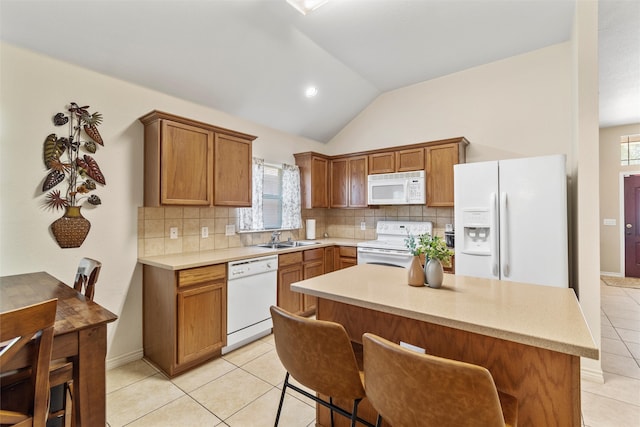 kitchen featuring white appliances, lofted ceiling, light tile patterned floors, and a wealth of natural light