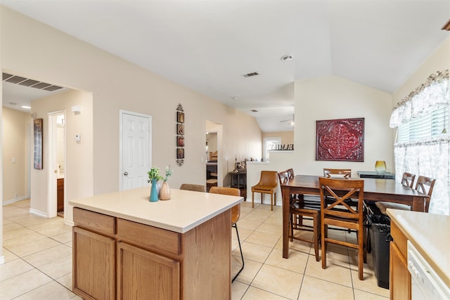 kitchen featuring lofted ceiling, a kitchen island, dishwasher, and light tile patterned floors