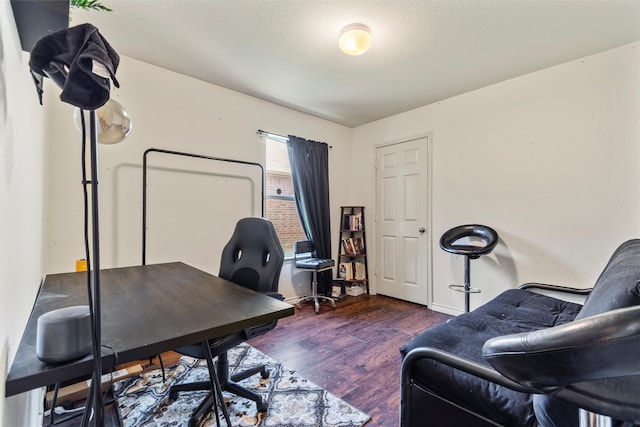 home office with a textured ceiling and dark hardwood / wood-style floors