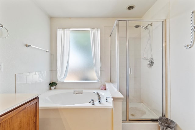 bathroom with vanity and shower with separate bathtub