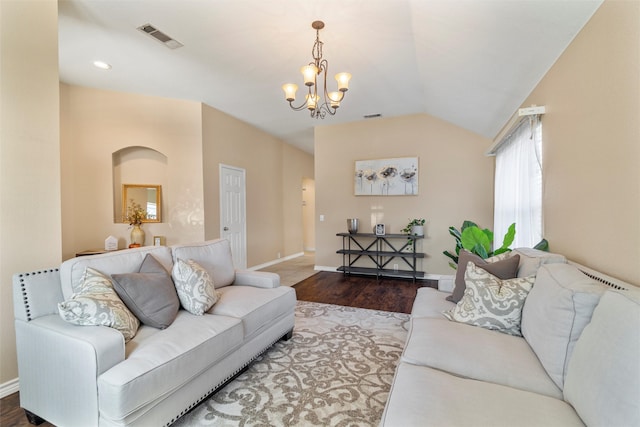 living room featuring hardwood / wood-style flooring, lofted ceiling, and a chandelier