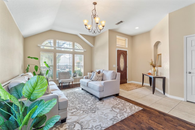 living room featuring light hardwood / wood-style floors, vaulted ceiling, and a chandelier