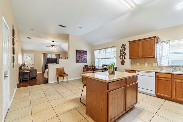 kitchen with light tile patterned floors, white dishwasher, a center island, ceiling fan, and sink