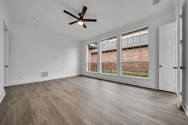 empty room featuring light hardwood / wood-style flooring, ornamental molding, and ceiling fan