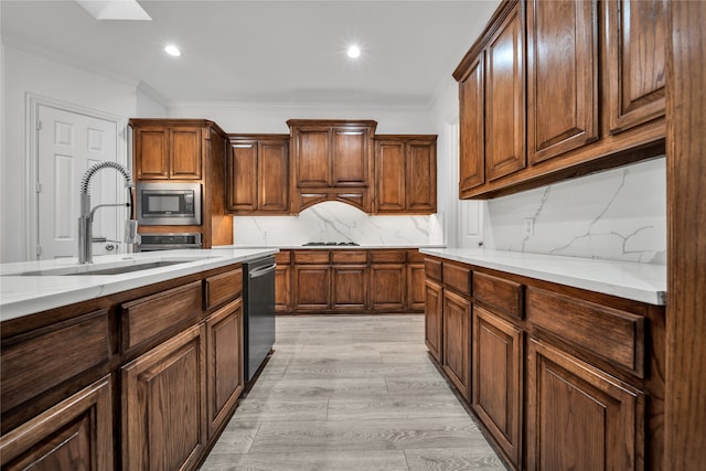 kitchen featuring sink, light hardwood / wood-style flooring, stainless steel appliances, tasteful backsplash, and light stone countertops