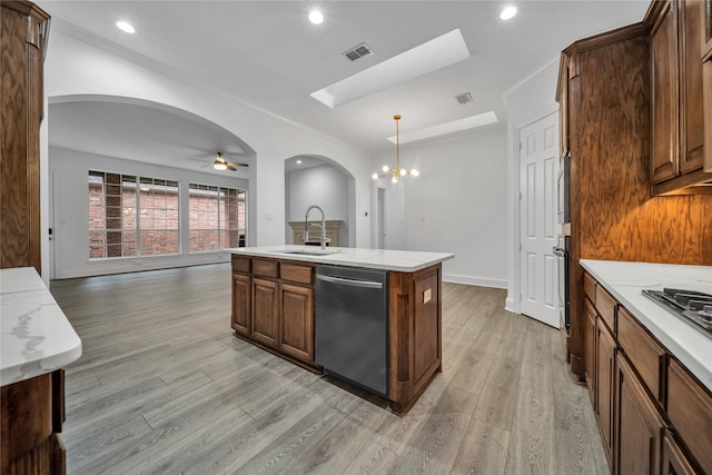 kitchen featuring sink, light hardwood / wood-style flooring, dishwasher, pendant lighting, and a kitchen island with sink