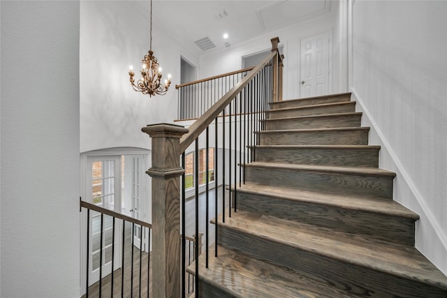 stairway featuring a towering ceiling and an inviting chandelier