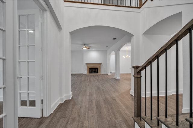 foyer entrance featuring wood-type flooring and ceiling fan with notable chandelier