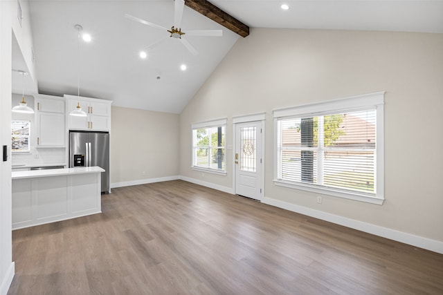 unfurnished living room featuring beam ceiling, ceiling fan, high vaulted ceiling, and light wood-type flooring