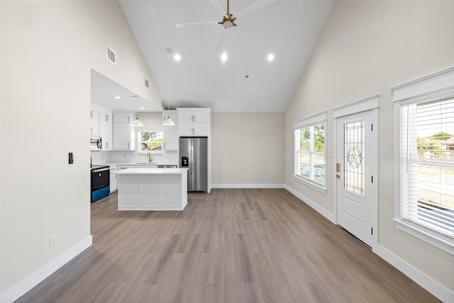 kitchen featuring appliances with stainless steel finishes, a kitchen island, ceiling fan, white cabinetry, and hanging light fixtures