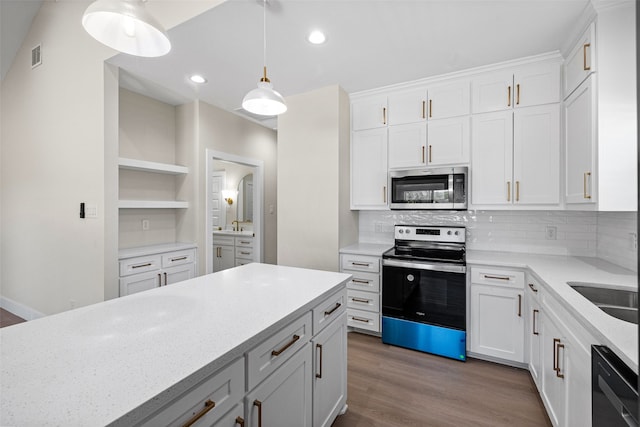 kitchen featuring white cabinets, hanging light fixtures, decorative backsplash, light stone countertops, and appliances with stainless steel finishes