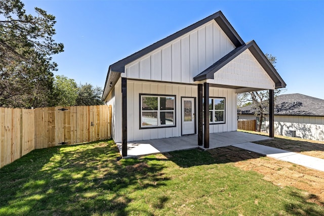 back of property with a patio area and a lawn