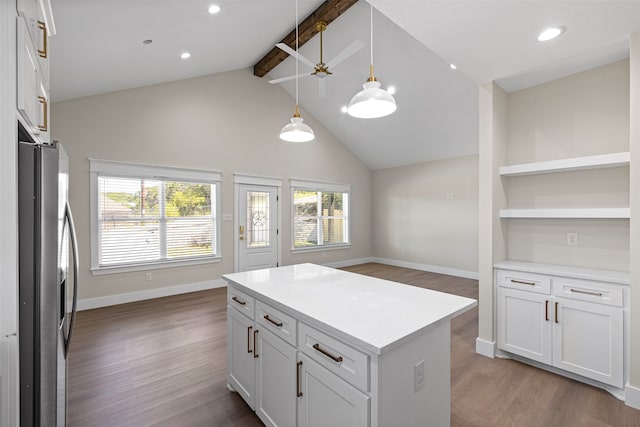 kitchen featuring stainless steel refrigerator with ice dispenser, pendant lighting, lofted ceiling with beams, light hardwood / wood-style flooring, and white cabinetry