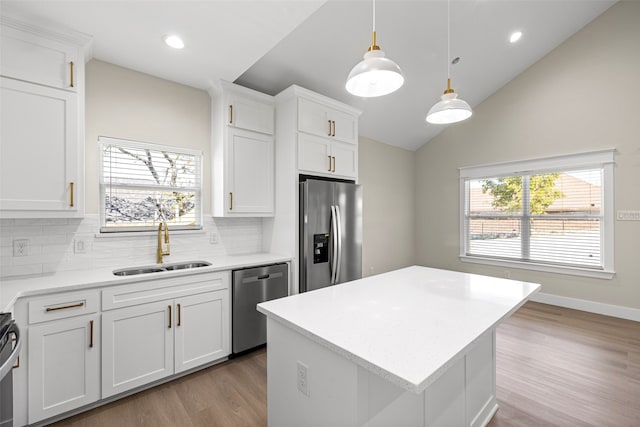 kitchen featuring appliances with stainless steel finishes, white cabinetry, and sink