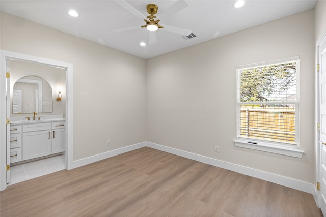 unfurnished bedroom with connected bathroom, light hardwood / wood-style flooring, ceiling fan, and sink