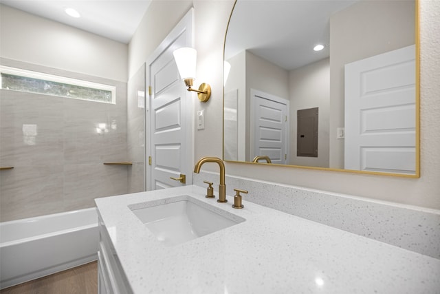 bathroom featuring electric panel, a bathing tub, and vanity