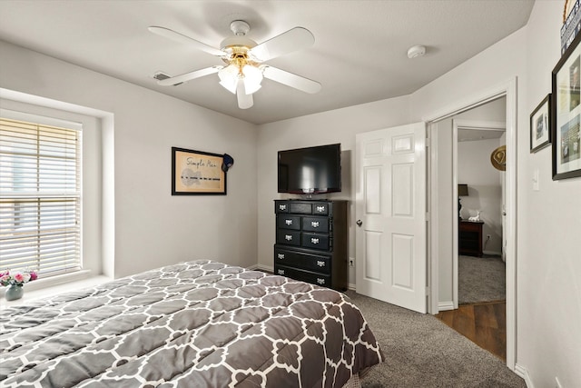 bedroom featuring dark colored carpet, ceiling fan, and a closet