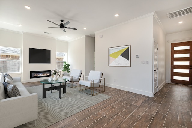 living room featuring a healthy amount of sunlight, ornamental molding, and dark hardwood / wood-style flooring