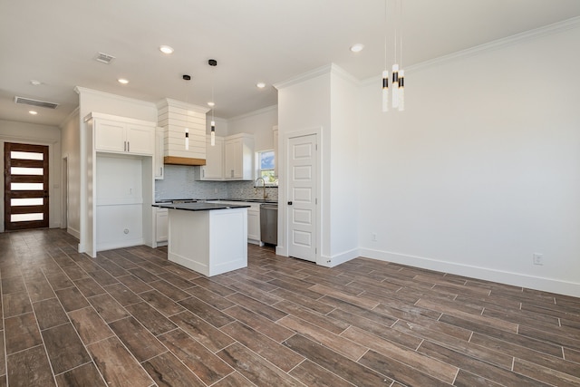 kitchen featuring pendant lighting, dark wood-type flooring, white cabinetry, a center island, and crown molding