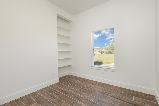 unfurnished room with dark hardwood / wood-style flooring