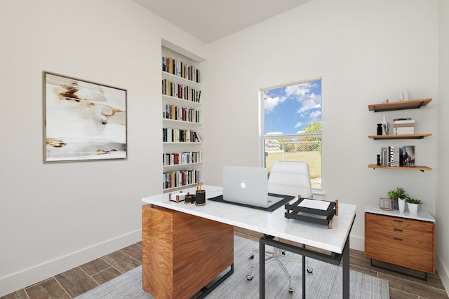 office area with built in shelves and hardwood / wood-style flooring