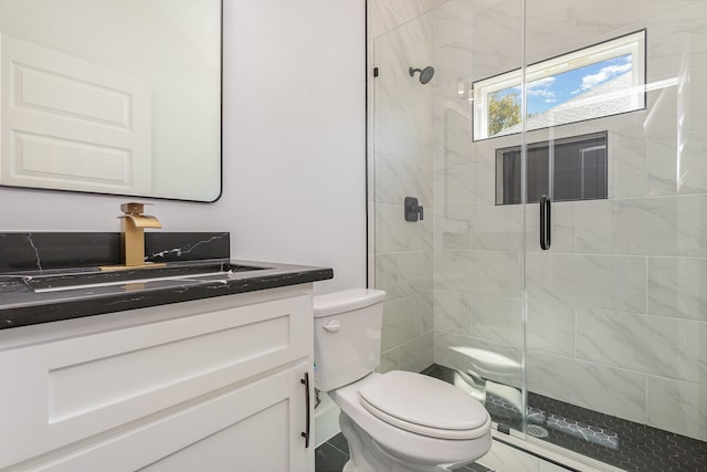 bathroom featuring vanity, toilet, and a shower with door